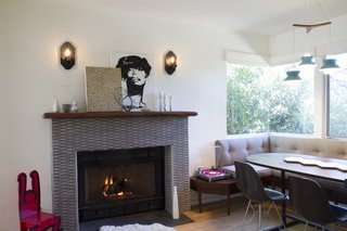 A husband-and-wife design team revived a 1940s home in East Los Angeles's Mt. Washington area for a single man. Bearing few tell-tale signs of bachelorhood, aside from a photography and music studio in the garage, the renovation retained the home's dual fireplaces and added an array of modern tiles. A transformed modern fireplace surrounded by Japanese tile flanks a custom banquette table in the dining/kitchen area.