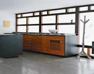 Wooten anchored the kitchen with a faux-bois coatrack from France. "Since Greg’s furniture is predominantly wood, we chose to make the interior all wood," says Massie. "We used laser-cut mahogany and cherry plywood with jigsaw edges to make the house more like a cabin—albeit a very modern one. This puzzle piece motif is something that I’ve done in every project before and after this one—it’s a different way of having surfaces come together without having to abide by a modernist rule of panels. We can snap the whole thing together with eccentric uniformity, and it’s really simple."