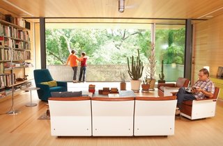 An architectural designer and an artist harnessed the collective power of their design firm to renovate a dilapidated mid-century gem into a hillside perch for their family.<br><br>Dieter Rams’s modular 620 Chair Programme, from the 1960s, takes center stage in the Alford-Young family’s living room. The set is accompanied by Artemide’s classic Tolomeo floor lamp and a Portofino Bergère chair that was designed by Rodolfo Dordoni for Minotti. The rolling glass doors running the length of the room are from Fleetwood.<br><br>Photo by: Brent Humphreys