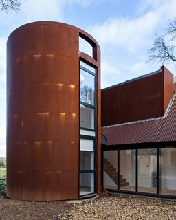 A circular tower echoes the former gas storage cylinder that once occupied its place. It houses a private study.