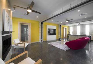 Contemporary, bright accents contrast with the dark concrete floors in the entertainment area.
