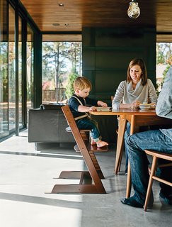 Amy and Jeremy Clark join their son, Edison, in the dining room; the Thatcher chairs by Newport Furniture and a dining table by Caperton of West Virginia are both from Room & Board. Edison’s high chair is the Tripp Trapp model by Stokke.