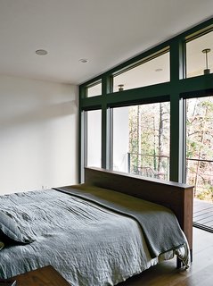 The master bedroom, which overlooks a lake across the street, is furnished with a Copenhagen bed by Wood Products for Room & Board.
