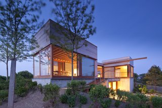 The abundance of windows in the design help break up the visual scheme of the rough-hewn wood façade, creating a visual line of sight through the house itself and furthering the connection to the views beyond.