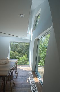 A suspended balcony on the second floor lets light pass easily through the house.
