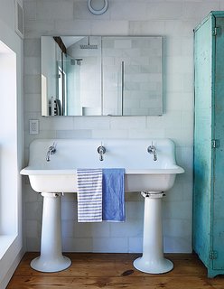The bathroom features a salvaged 1920s schoolhouse sink from Olde Good Things. The faucet mixers are by Jado; the original single tap openings were enlarged to fit them, and the entire sink was re-glazed.