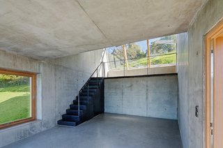 Camera-Inspired Artist's Studio Offers Stunning, Wide-Angle Views - Photo 5 of 7 - The single skylight helps light the artists' workstation. The simple interior, really a shed with smooth concrete surfaces, provides a stark yet airy space for creative pursuits.