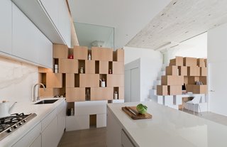 This living/dining space is the social center of the apartment. For that reason, the architect designed the cabinet walls as a unifying visual feature that anchors the two rooms and provides practical storage space.