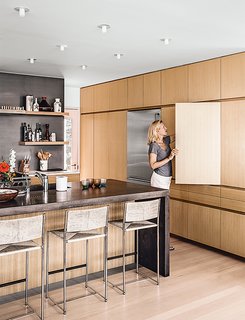 Kitchen cabinets in Japanese elm are topped with Calacatta marble and wraparound concrete for the island.
