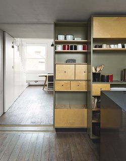 A sliding storage wall can be tucked aside to allow a seamless connection to the living and dining area.
