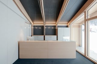 All of the interior furnishings were designed and built by LEAPfactory for this specific project. These pieces, including the reception desk, are made of laminated boards and the same reforested beech wood used in the school’s structure. A door behind the reception desk leads to a living room for the ski and snowboard instructors.