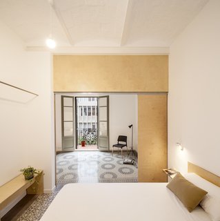 The open wardrobe is simply a bench with a single rod traversing the bedroom.