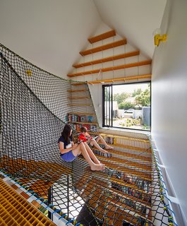 Inspired by the Sydney Opera House, Austin Maynard Architects paid careful attention to this home's "fifth elevation"—the way it’s seen from the sky. "The roof plan, rather than the street façade, is now the most public face of a building thanks to Google Earth," they explain. The Tower House is made up of tiny houses, clustered at the southern end of the property and clad in white steel panels and western red cedar shingles. Spinning off the living room on the north side of the main house, the children’s study sits separate from the other pavilions. On its upper level, Oxley netting forms a web on which the kids and their friends can sit and read with views of the leafy street and garden.
