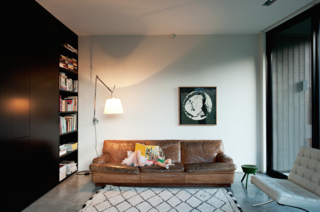 The architect specifically chose a palette of natural finishes, including the polished concrete floor that flows the length and breadth of the ground level.<br><br>By way of contrast, the couple’s eclectic collection of much-loved vintage furniture, including Mies van der Rohe Barcelona chairs, an Artemide lamp, and this 50-year-old sofa by mid-century Swedish designer Arne Norell, provide color and warmth. "The bookcase also makes use of space to add layers of texture. Books are always a great addition to any interior," says Cooke.<br><br>The Beni Ouarain rug was purchased on a trip to Morocco.