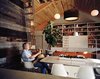 Modern home with Dining Room, Table, Chair, and Pendant Lighting. Color and material cues help Matthew navigate the house. Reclaimed wood from a local barn marks the dining room, which also features a table from BoConcept, a Graypants pendant lamp, and molded-fiberglass chairs by Charles and Ray Eames. In the living room, the color palette of the Design Within Reach sofa and built-in bookshelves was inspired by maple trees in fall. “That’s really what universal design is about: making it as stylish as anything you’d put in anyone else’s house, but having the ability for it to be accessible,” says Coplen. Photo of Examples of Rustic Modern Done Right