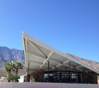 Visitors entering Palm Springs from other desert cities will first come upon the Palm Springs Tramway gas station, designed in 1965 by Albert Frey and Robson Chambers, topped by a hyperbolic paraboloid roof.