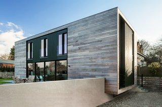 On the patio, occupants can take in the views from the oak chairs and table. The home’s rectilinear form was achieved using structural insulated panels that were flat packed and efficiently assembled on site. An integrated steel frame allows for the large openings onto the garden.
