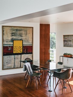 In the dining room, artworks by Alan Davie (at left) and Martin Bradley join a Norman Foster dining table.
