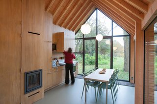 Fine wood craftsmanship defines the dwelling's interior, where all the facilities—from the kitchen cabinets to the fireplace to the bathroom—are integrated into a single oak wall, handmade by van Norel. He also made the dining table, which is paired with Philippe Starck master chairs—the only ready-made items in the space other than fixtures and appliances.