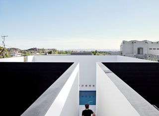 The pool is sheltered on all sides by white plaster walls, a space envisioned by the architect as a volume that's "half terrace, half cool-water retreat...projected toward the canopy of the desert sky."