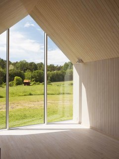 Full-height glazing caps the central living area. A rigid steel frame concealed within its wood envelope allows for uninterrupted sight lines and creates a single, open-plan living space.