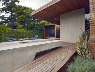 An Indoor-Outdoor Renovation for a 1950s Ranch House in the Bay Area - Photo 3 of 8 - A spacious deck was created as part of the addition. A cantilevered concrete bench stretches out to the rear garden and complements the adjacent concrete wall.