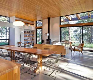 A Serene, Sustainable Home in Colorado - Photo 4 of 10 - Tall, sliding glass panels extend along the west side of the house, including into the living area, which has views across the terrace and 35-acre wooded property. Built-in bookshelves, part of Dynia's thick-wall strategy, keep with the orderly design. <br><br>Photo by Ron Johnson.