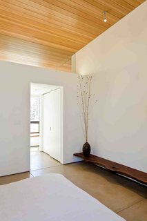 A Serene, Sustainable Home in Colorado - Photo 5 of 10 - Concrete floors, wood ceilings, and unadorned walls are intentionally monastic. Boulder culture centers around a concern for the environment, which the owners—with their desire to limit material waste—adopted. Local company TCWoods made the bench from a piece of walnut. <br><br>Photo by Ron Johnson.
