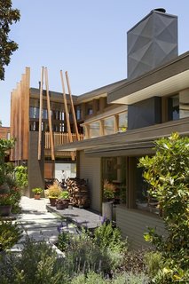 By combining and unifying the landscape design of his house and that of his mother-in-law next door, Clementi was able to maximize his yard and execute a design that includes graded concrete steps, vegetable gardens, and a massive magnolia tree.