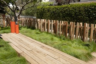 A small fence in the yard echoes the posts that support the new master suite.