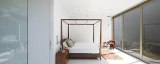 A Modern Concrete Home in Peru - Photo 4 of 13 - In the master bedroom is a four-poster bed by Javier Rubio and a vintage Warren Platner chair.