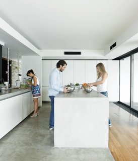Alexia, Achilleas, and friend Fotini prepare lunch in the kitchen, outfitted with cabinets by Zeyko.