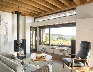 The living room is furnished with a Tolomeo Mega floor lamp by Artemide, a Milo Baughman Recliner 74, a Morsø 7648 wood stove, and a Hampton rug by Capel Rugs.