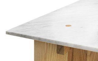 Here's a detail of the table. It's held together by the weight of the marble slab used as a top. "I wanted to keep the construction as clean and simple as possible so I looked into traditional joints used in basic carpentry," says Fjetland. "It might sound silly, but one of the key attributes of stone is that it’s rather heavy. I used the weight of the tabletop to lock the whole construction. The wooden pegs keep the stone in place and they are also prevent the solid wood flanges from getting deformed by humidity."