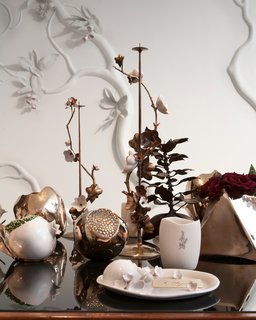 A detail of the dining table tableau at David Wiseman’s exhibition at R 20th Century, 2012. The matchsticks held in the white porcelain pomegranate at left cleverly signify the fruit’s seeds. Photo by: Sherry Griffin/R 20th Century.