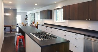 Paperstone countertops and custom cabinets outfit the kitchen. The cooktop is by Whirlpool.