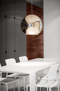 Goneau matched Audrey Chairs from Kartell with a dining table she designed herself. "It becomes the visual continuity of the kitchen island, by its dimensions and material," she says. A bronze copper pendant by Tom Dixon hangs above it.