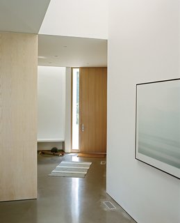 A custom entry door by Creekside Millwork is positioned diagonally from the home’s rectilinear form.