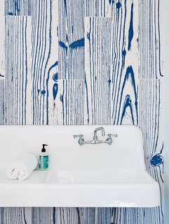 White-and-blue, wood-grain–patterned UonUon tiles by 14oraitaliana line the bathroom walls in a loft above the garage.