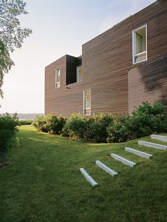 The home is defined by two types of windows: large punch openings for views onto the landscape and vertical windows everywhere else.