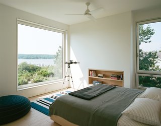 In the master bedroom, a custom ash frame takes advantage of the expansive view.