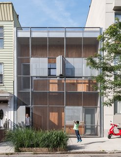 The Baumann family residence in Gowanus, Brooklyn, is all geometry up front, with a rectilinear grid of steel and cypress comprising the structure’s double facade.