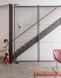 The sculpture on the wall is by artist Peter Dudek, a friend of the family, and the pendants are by Glashütte Limburg. Baumann made a point to integrate industrial materials throughout, exposing steel beams and setting the floor in concrete.