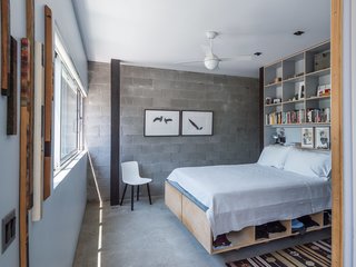 Baumann designed the plywood bed frame and shelving unit in the master bedroom, adjacent to an exposed cinder-block wall, a new addition to the structure.