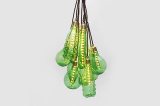 Studio Swine's hanging light pendants are crafted out of various glass beverage bottles. The clean and high quality glass is broken down into cullet, then each bulb is specifically formed and fitted and accented with brass fittings.