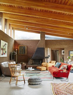 In the open-plan living and dining room, a dramatically sloped roofline allows for generous clerestory windows.