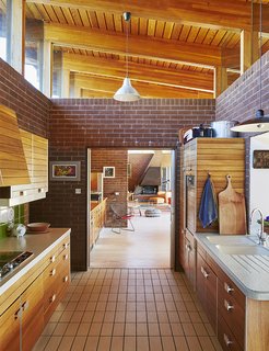 The mahogany-paneled Poggenpohl kitchen system is original to the house. The kitchen opens to the living and dining area.
