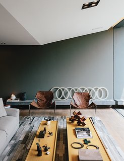A Lush Retreat With a Sheltered Rooftop Pool in Mexico City - Photo 2 of 14 - In the sitting area, two leather Paulistano chairs by Paulo Mendes da Rocha top a rug by Yerra; the wall paint is Comex.
