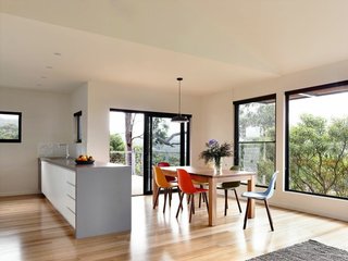 The central living area features an open-plan kitchen, living space, and deck with views of Louttit Bay. To maximize energy savings, the house has a ducted reverse air cycle system from Fujitsu.