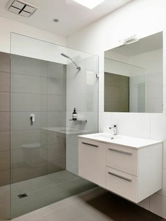 "Keeping the kitchen and bathrooms simple saved money for the important things," Harkness explains. They went with a soothing color palette and hardware from Reece.